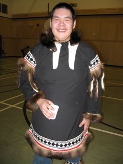 Young Inuit man in dancing costume with wolverine trim.