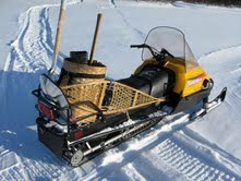 My traveling snowmobile - with snowshoes, scoop shovel, and axe on board. A rifle and matches - with birch bark fire kindling - are other important survival items.